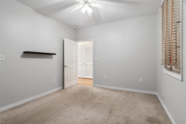 unfurnished bedroom featuring light colored carpet and ceiling fan