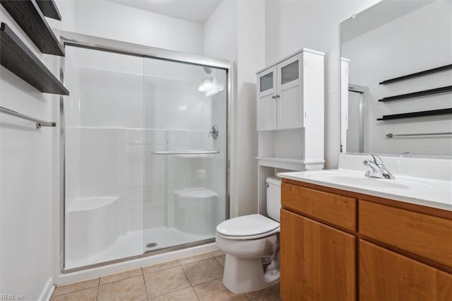 bathroom featuring toilet, tile patterned flooring, a shower with shower door, and vanity