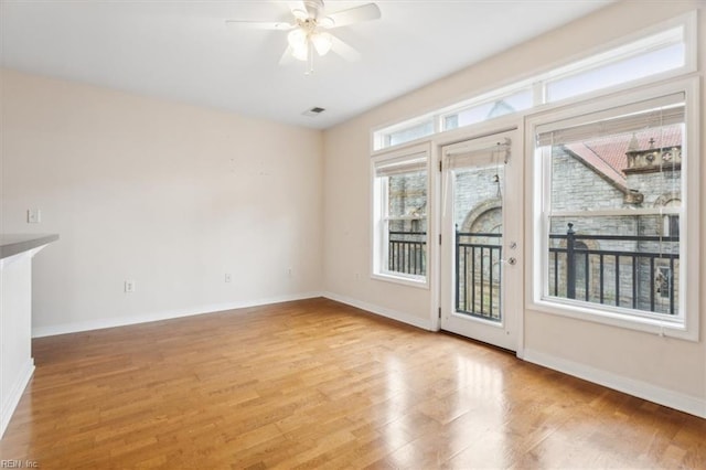 interior space with ceiling fan, a wealth of natural light, and light hardwood / wood-style flooring