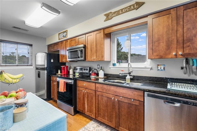 kitchen featuring sink, plenty of natural light, light wood-type flooring, and stainless steel appliances