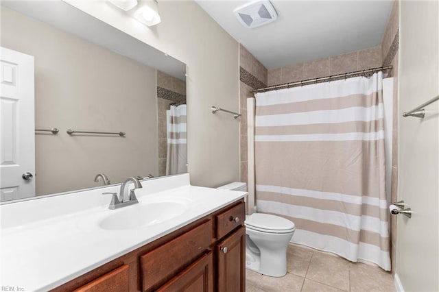 bathroom with toilet, vanity, and tile patterned flooring