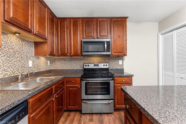 kitchen with sink, backsplash, dark hardwood / wood-style flooring, and appliances with stainless steel finishes