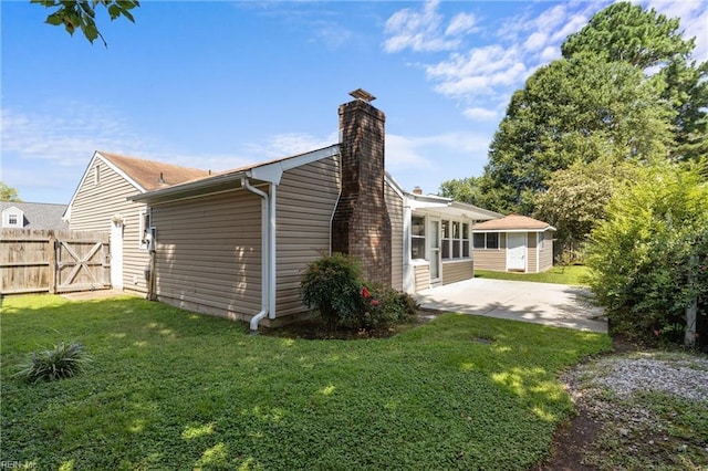 rear view of house with a lawn and a patio