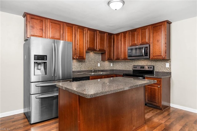 kitchen featuring appliances with stainless steel finishes, sink, dark hardwood / wood-style floors, a kitchen island, and decorative backsplash