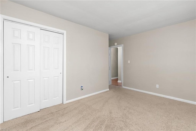 unfurnished bedroom featuring a closet and light carpet