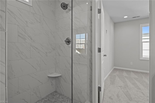 bathroom featuring a tile shower and a wealth of natural light