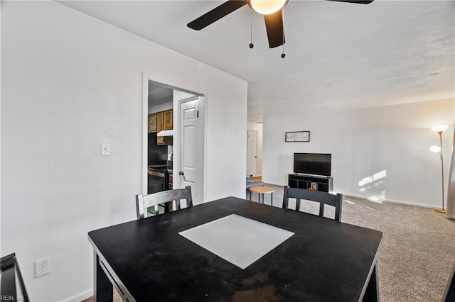 carpeted dining space with ceiling fan