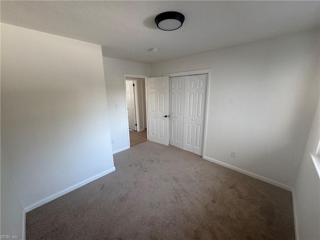 unfurnished bedroom with a closet and carpet flooring