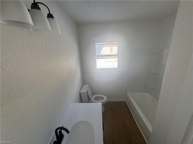 bathroom featuring hardwood / wood-style flooring, toilet, and shower with separate bathtub