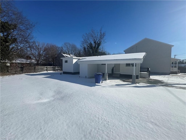 snow covered property featuring a carport