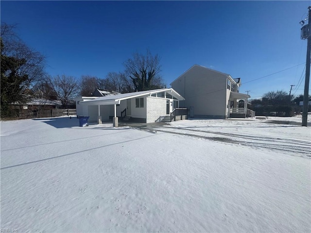 view of snow covered back of property