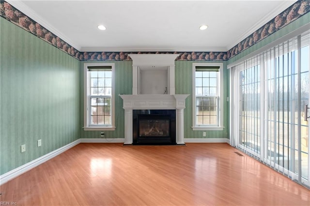 unfurnished living room featuring a fireplace, hardwood / wood-style floors, and ornamental molding