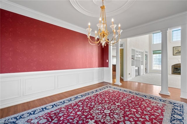 interior space featuring ornamental molding, hardwood / wood-style flooring, and ornate columns