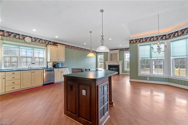 kitchen featuring pendant lighting, appliances with stainless steel finishes, a center island, and a healthy amount of sunlight