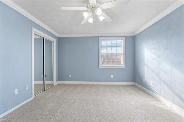 unfurnished bedroom featuring a closet, ceiling fan, crown molding, and light carpet