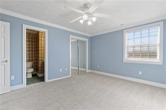 unfurnished bedroom with carpet flooring, a closet, ornamental molding, ceiling fan, and connected bathroom