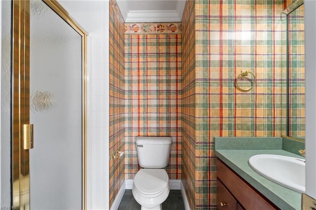 bathroom with a shower with shower door, toilet, vanity, and crown molding