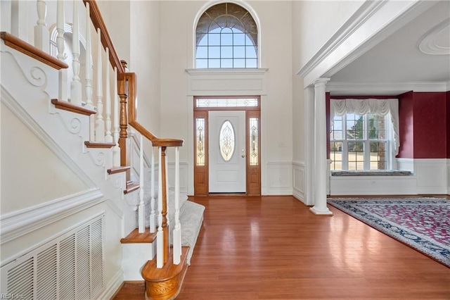 entryway featuring dark wood-type flooring and ornate columns