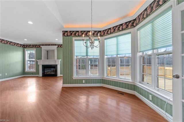 interior space with a notable chandelier, hardwood / wood-style flooring, and a wealth of natural light