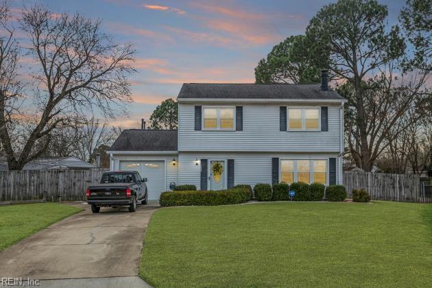 front facade featuring a garage and a yard