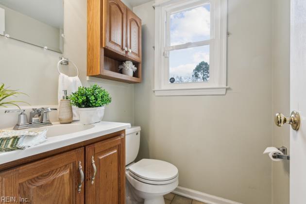 bathroom featuring toilet, vanity, and tile patterned flooring