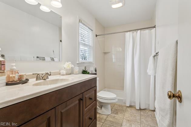 bathroom with toilet, vanity, and a shower with curtain