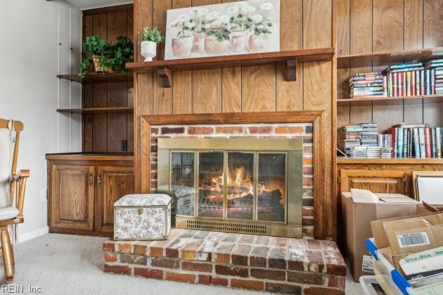 interior space with light colored carpet and a brick fireplace