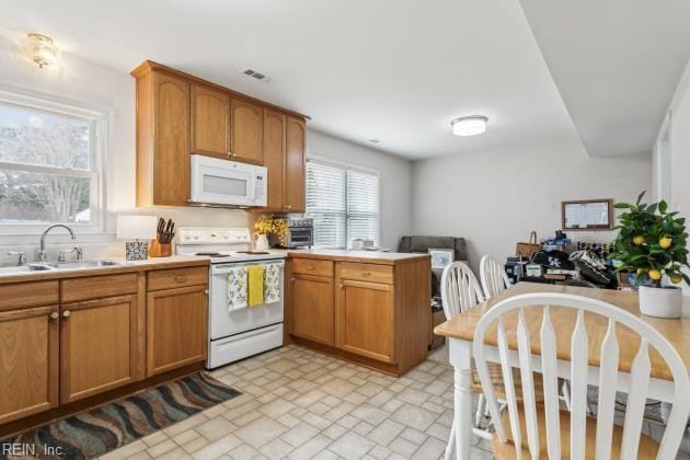 kitchen featuring sink, white appliances, and kitchen peninsula