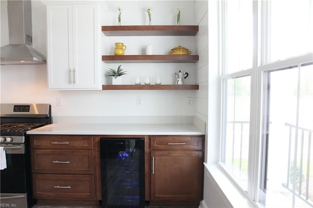 bar featuring gas range, wall chimney exhaust hood, and wine cooler