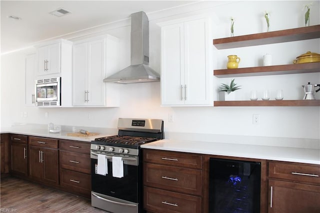 kitchen with wine cooler, white cabinetry, appliances with stainless steel finishes, and wall chimney range hood