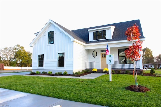 view of front of home with covered porch and a front lawn