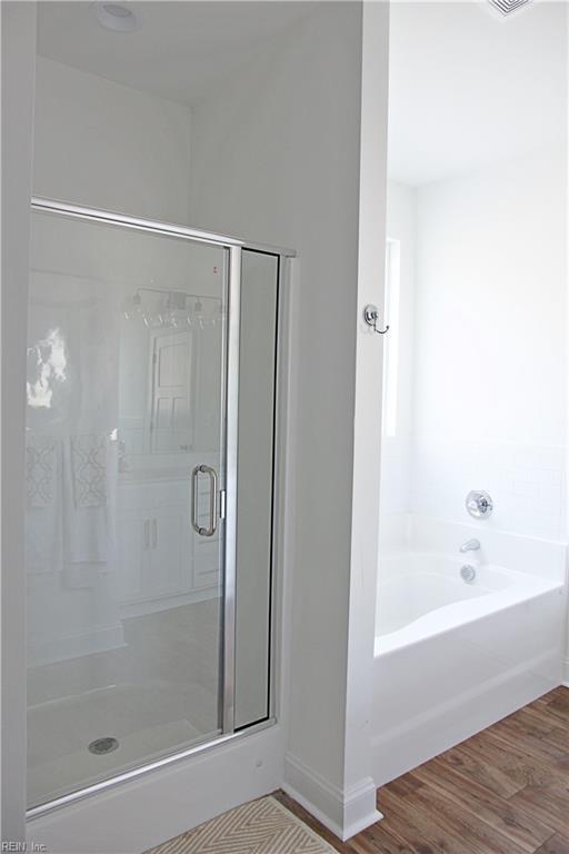 bathroom featuring independent shower and bath and hardwood / wood-style floors