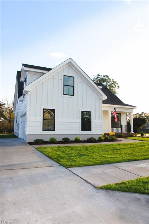 modern inspired farmhouse featuring a garage, a front yard, and covered porch