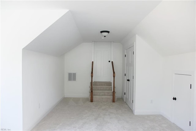 additional living space with lofted ceiling and light carpet