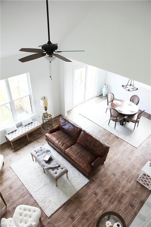 living room with wood-type flooring, high vaulted ceiling, and ceiling fan