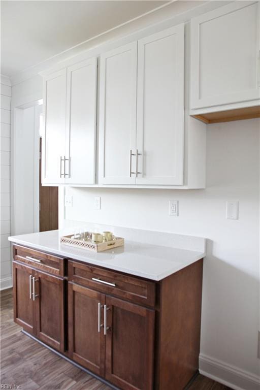 kitchen featuring white cabinetry, ornamental molding, and hardwood / wood-style floors