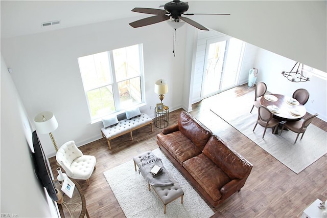 living room with hardwood / wood-style flooring, ceiling fan, and lofted ceiling