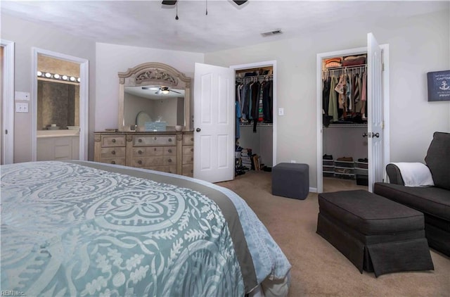 bedroom featuring light carpet, ceiling fan, and ensuite bathroom