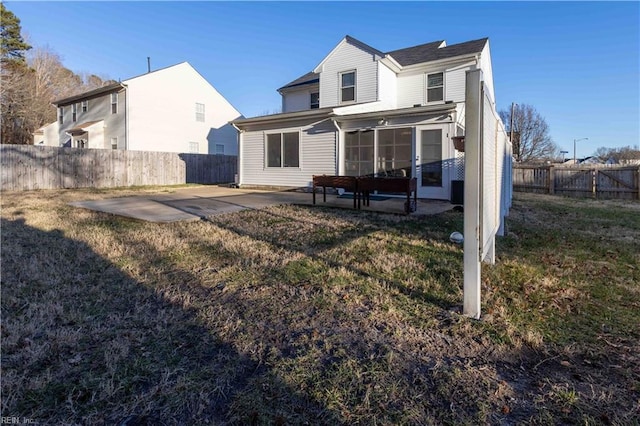 back of property with a yard and a patio