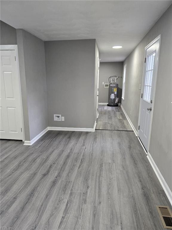 interior space with hardwood / wood-style floors and electric water heater