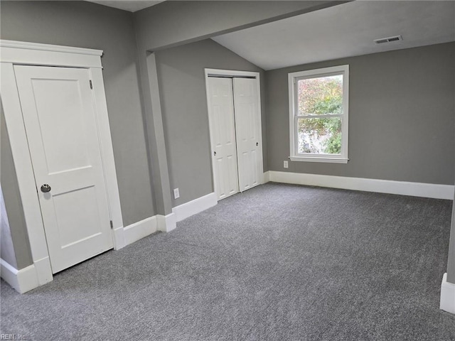 unfurnished bedroom with a closet, lofted ceiling, and carpet flooring