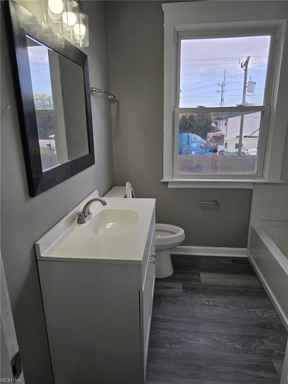 bathroom featuring hardwood / wood-style floors, toilet, a wealth of natural light, and vanity