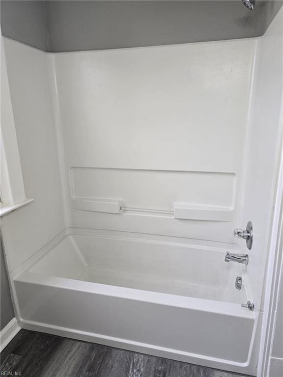 bathroom featuring hardwood / wood-style floors and  shower combination