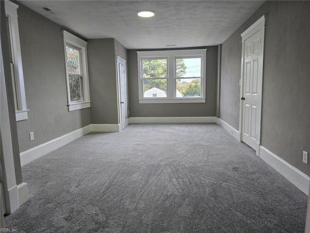 empty room with a textured ceiling and carpet flooring