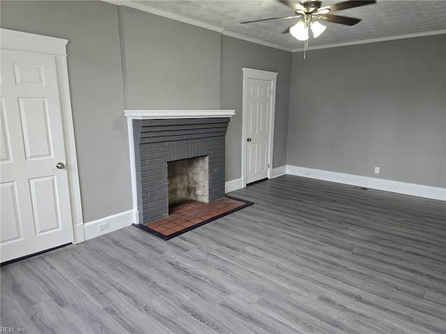 unfurnished living room featuring ceiling fan, hardwood / wood-style floors, a brick fireplace, and ornamental molding