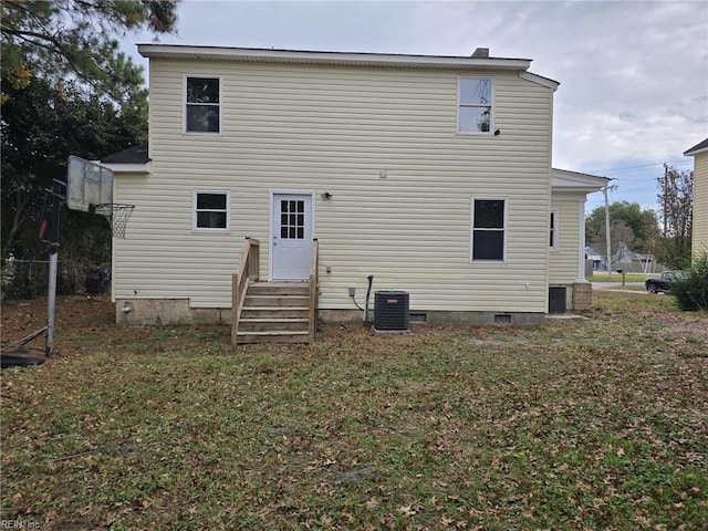 back of property with central air condition unit and a yard