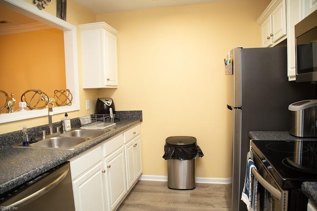 kitchen with sink, light hardwood / wood-style floors, white cabinets, and appliances with stainless steel finishes