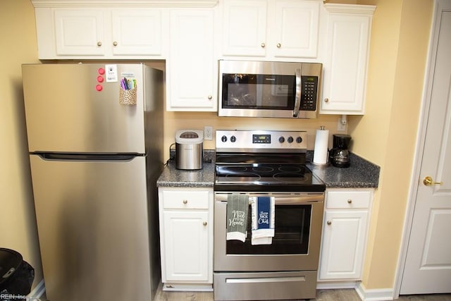 kitchen featuring stainless steel appliances and white cabinetry