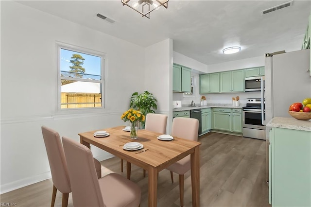 kitchen featuring green cabinetry, dark hardwood / wood-style floors, and stainless steel appliances