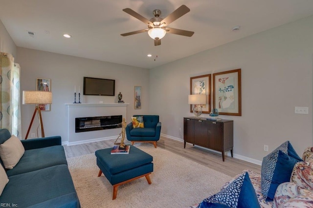 living room with light hardwood / wood-style flooring and ceiling fan